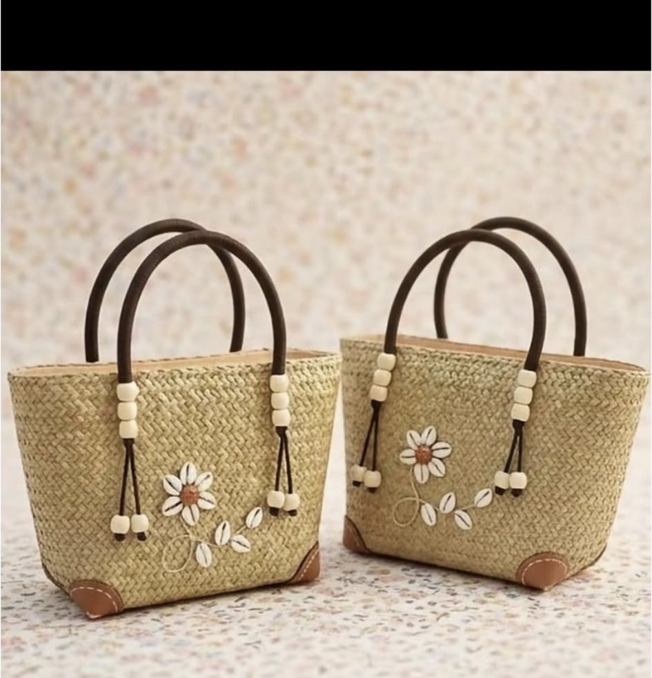 Two handwoven straw totes with daisy appliqué and wooden arch handles