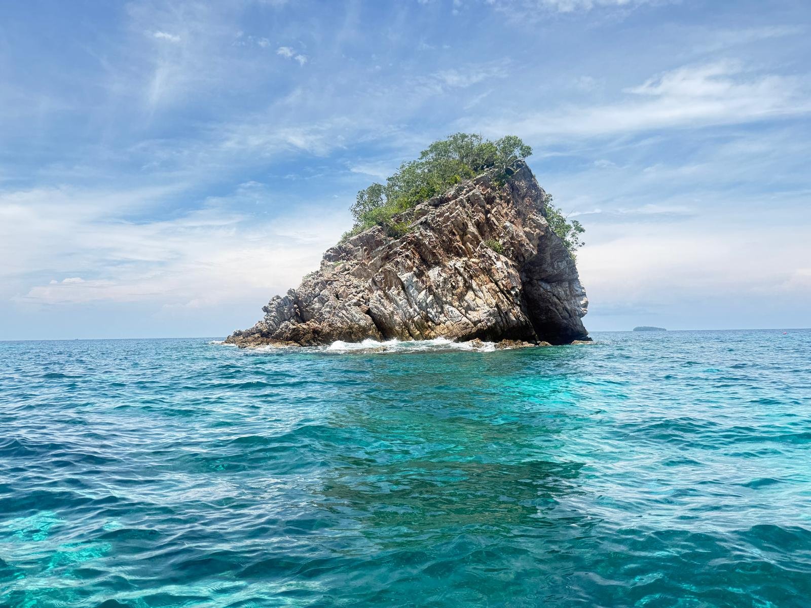 A rocky islet rising out of turquoise water near Koh Lipe