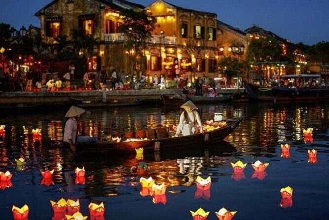 Lantern-lit boats and historic buildings along the river in Hoi An, Vietnam
